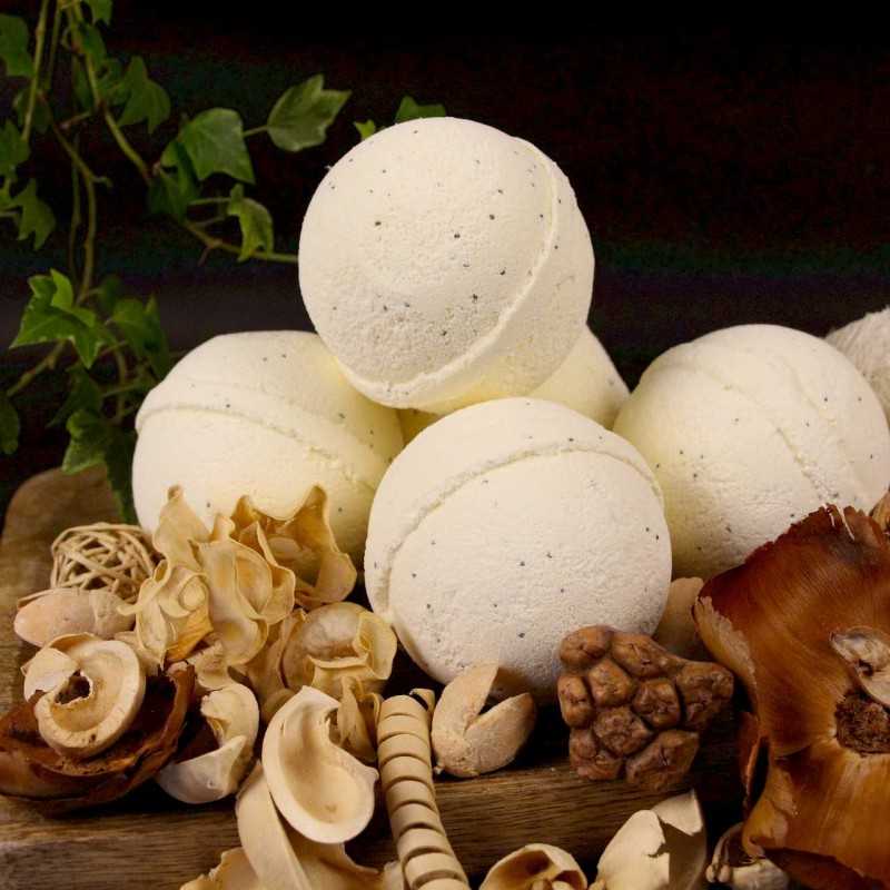 Plusieurs bombe de bain artisanale au beurre de karité et à la vanille posées sur une planche en bois de manguier